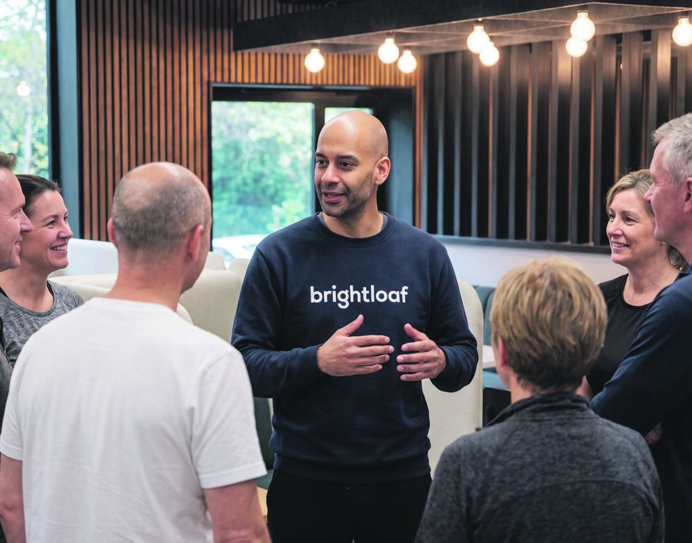 Neil Singh, a GP and brightloaf's founder, talking with a group of staff at The Oakwood in Esher